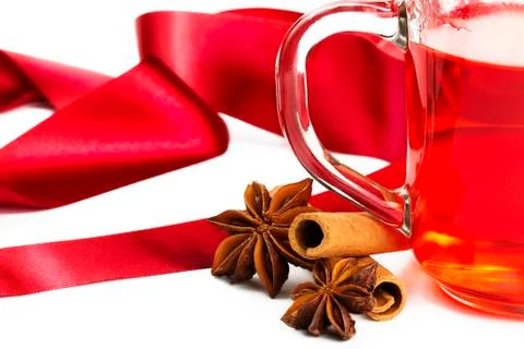 Half red tea cinnamon sticks star anise and red ribbon Stock Photos