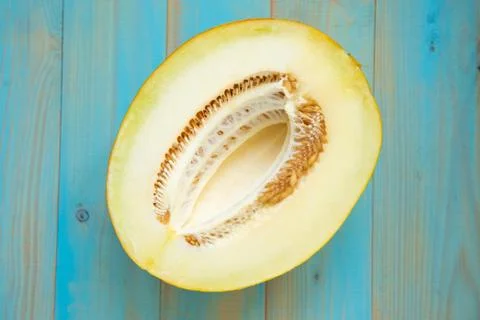 Half ripe melon on a rustic, blue wooden background Stock Photos