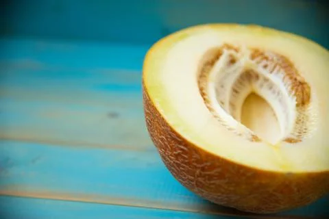 Half ripe melon on a rustic, blue wooden background Stock Photos