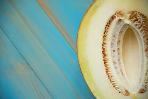 Half ripe melon on a rustic, blue wooden background Stock Photos