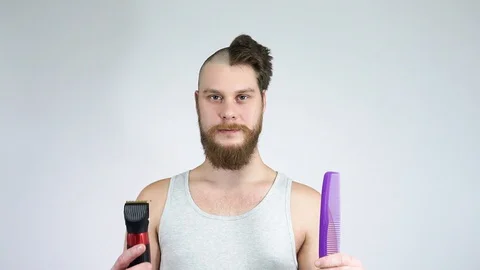Half shaved man holding a clipper and a comb.The concept of before and after. Stock Footage 122217777