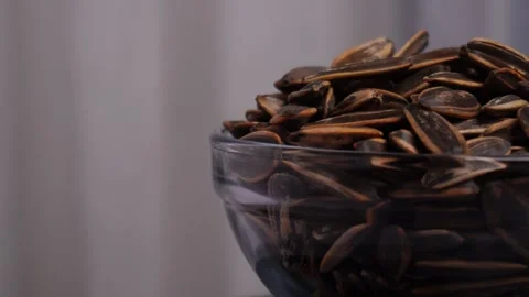 Half side view of the spinning bowl of sunflower seeds Stock Footage 275488961
