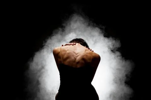 Half silhouette modern ballet dancer posing on dark background with smoke Stock Photos