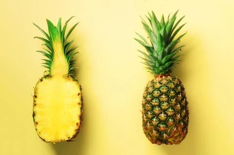 Half slice of fresh pineapple and whole fruit on yellow background. Top View Stock Photos