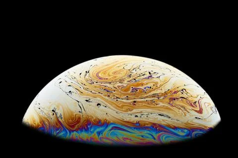 Half a soap bubble on a black background. Abstract pattern. Stock Photos