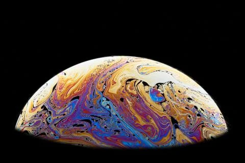 Half a soap bubble on a black background. Fantastically vibrant color pattern Foto stock
