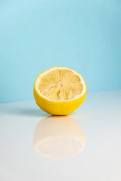Half of squeezed lemon on white table Stock Photos