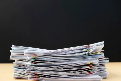 Half of Stack of document paper with colorful paperclip place on wooden table Stock Photos