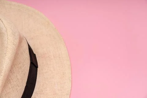 Half a straw hat on a pink background. Conceptual photo. Close-up. Copy space. Stock Photos