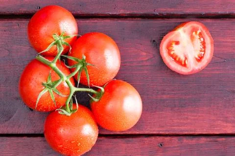 Half of a tomato with cluster over dark table Stock Photos