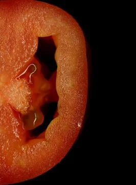 Half tomato slice on black background detail Stock Photos