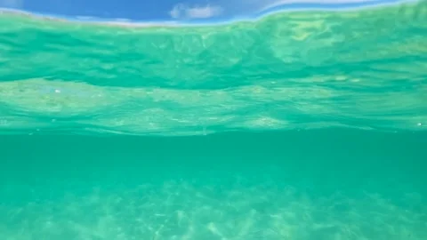 Half underwater slow motion of clear turquoise sea water. Idyllic vacations in Видео 243187361