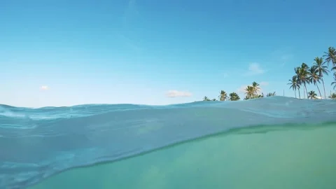 Half underwater slow motion clear blue sea water at the tropical beach at sunset Stock Footage 243572687
