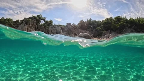 Half underwater slow-motion shot of tropical beach with crystal clear sea water Stock Footage 221248027