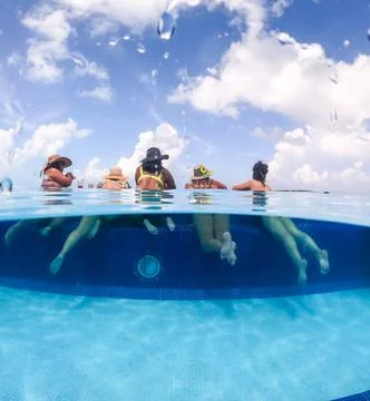 Half underwater split image of young women having fun in hotel pool in Caribbean Stock Photos