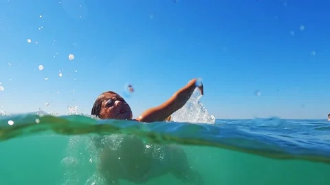 Half underwater view of little child girl learning to swim. Slow motion Video stock 221925990