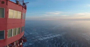 Half view of the red TV tower. The copter is circling around the tower at the Stock Footage 85899601