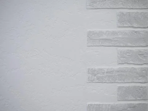 Half of the wall is finished with white plaster and the other half with white Stock Photos