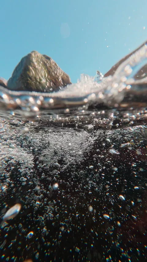 Half water shot, Silver bubbles rush past, revealing hidden, turbulent life of Stock Footage 338136100