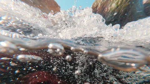 Half-water shot: violent, silver air bubbles speedy flowing underwater Stock Footage 330109858