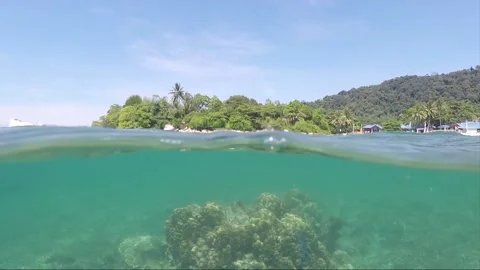 Half water split shot, Corals with Perhentian Island on the background, Malaysia 動画素材 197575599