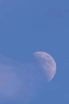Half white moone with cloud on side by daylight Stock Photos