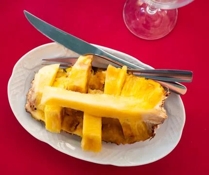 Half of whole pineapple fruit is served on plate Stock Photos