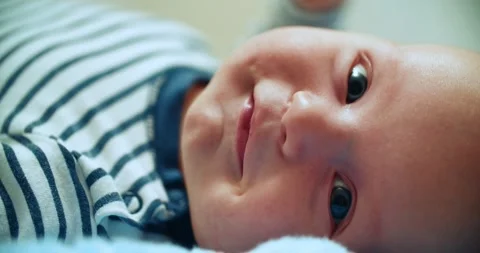 A half-year-old boy looks directly into the camera in close-up. Little cute baby Stock Footage 261966418