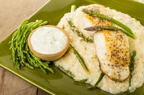 Halibut with asparagus risotto on green plate Stock-Fotos