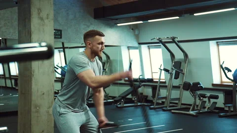 In the hall for crossfit a strong man pulls two ropes simultaneously. Stock Footage 90364011