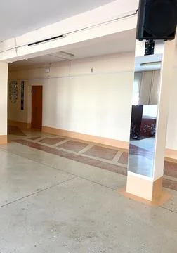 Hall in an old school featuring a polished floor, large mirror, and simple decor Stock Photos