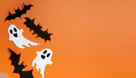 Halloween background with black paper bats, ghosts and spiders on orange backgro Stock Photos