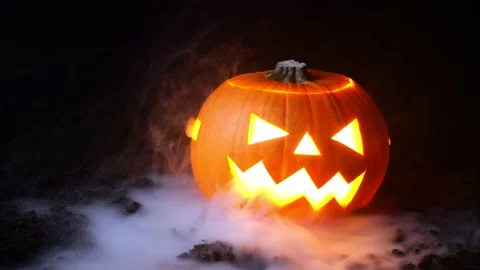 Halloween background. Light, smoke and pumpkin on a black background. Stock Footage 230235073