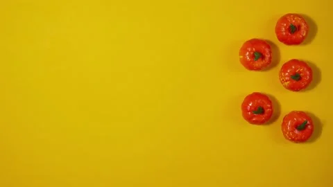 Halloween background with moving plastic decorative pumpkins on a yellow back Stock Footage 192467727
