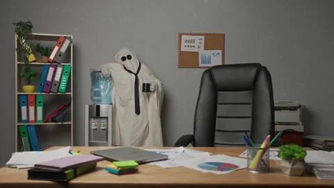 Halloween businessman ghost in white sheet standing in office drinking water Stock Footage 313387232