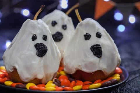 Halloween candy pears or white chocolate ghosts on a stick Stock Photos