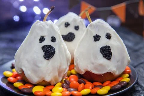 Halloween candy pears or white chocolate ghosts on a stick Stock Photos
