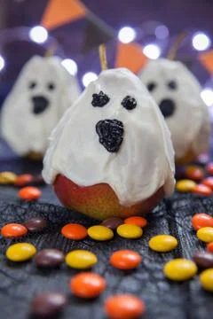Halloween candy pears or white chocolate ghosts on a stick Stock Photos
