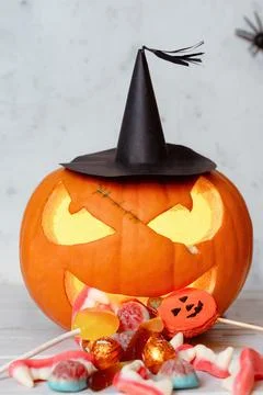 Halloween Carved Pumpkin With Witch Hat Spewing Halloween Candy Foto stock