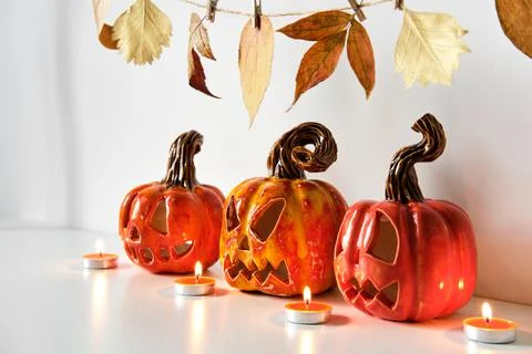 Halloween composition with ceramic pumpkins jack lantern and candles on table Stock Photos
