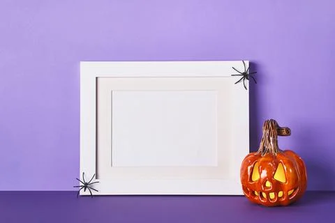 Halloween composition with ceramic pumpkins jack lantern and frame on table w Stock Photos