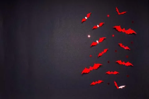 Halloween composition. Flock of red bats and spiders on black background. Hap Stock Photos