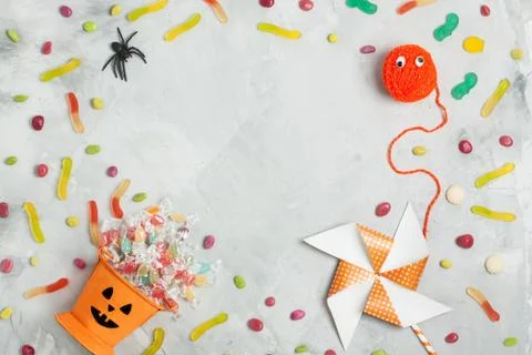 Halloween composition with orange candy bucket, jujubes, spider and whirligig Stock Photos