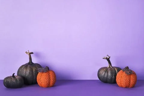 Halloween composition with pumpkins on violet background. Greeting card templ Stock Photos