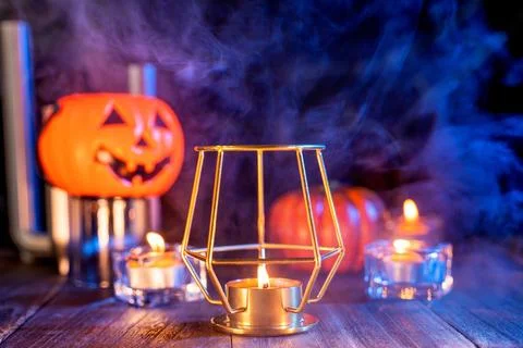 Halloween concept, orange pumpkin lantern and candles on a dark wooden tabl.. Stock Illustration