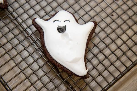 A halloween cookie in the shape of a ghost or ghoul on a baking trey with w.. Foto stock