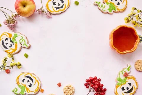 Halloween creative concept background: pumpkin cup and cookies in shape of cute Stock Photos