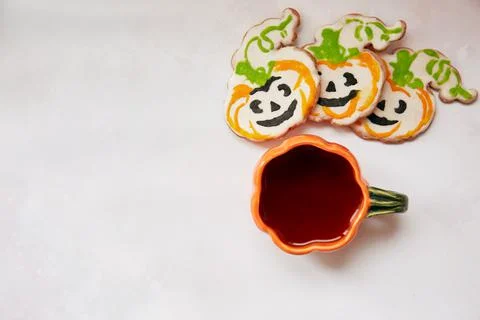Halloween creative concept background: pumpkin cup and homemade cookies in shape Stock Photos