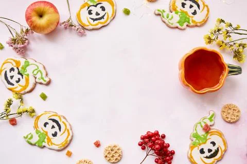 Halloween creative concept background: pumpkin cup and cookies in shape of cute Stock Photos