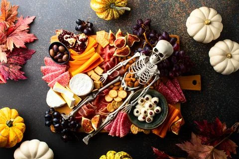 Halloween dark  table setting with cheese board decorated with spooky scary s Stock Photos